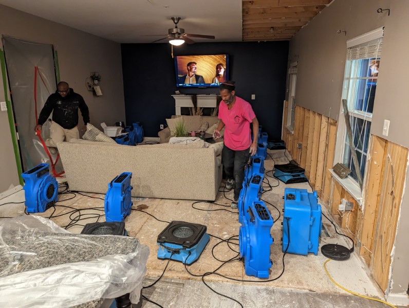 living room water damage restoration by Top To Bottom Renovation