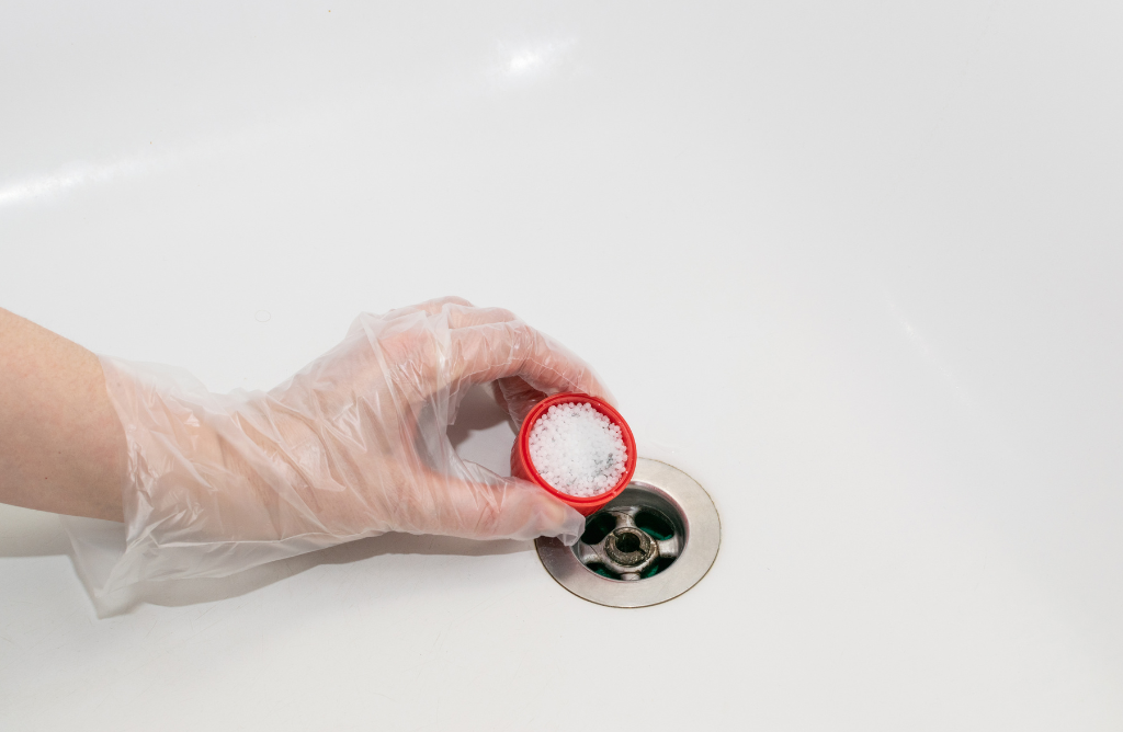Putting-a-mixture-in-the-shower-drain-to-unclog-it
