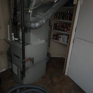 Basement HVAC furnace unit in utility room during water damage inspection and restoration