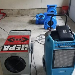Industrial dehumidifiers and air movers set up for water damage drying.