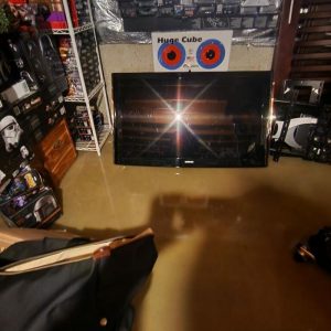 Basement entertainment room flooded with standing water around television and furniture
