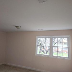Freshly painted bedroom with new windows and ceiling lights after renovation