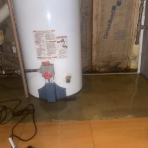 Flooded basement floor around water heater with standing water after plumbing leak