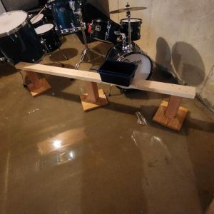 Flooded basement with standing water around drum set and wooden supports