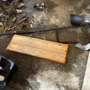 Removed flooring board lying on a damaged floor.