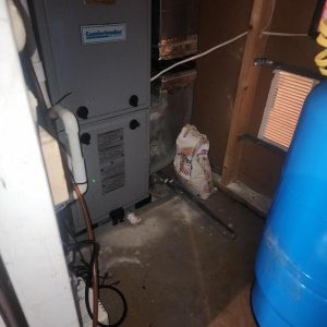 Utility closet with furnace and standing water during water damage inspection and cleanup