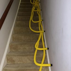 Drying hoses placed along staircase during water damage restoration process