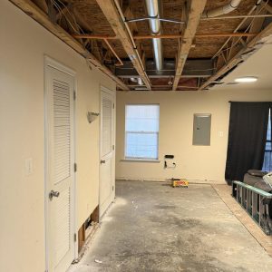 Interior room with exposed ceiling and flooring during renovation.