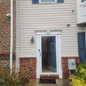 Townhouse back entrance with glass storm door during restoration service visit
