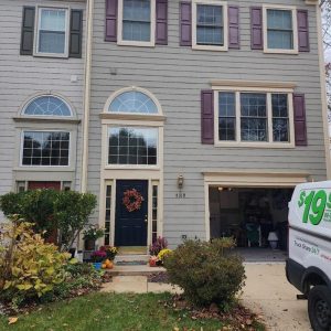 Townhouse exterior with open garage and service van parked in driveway during restoration visit