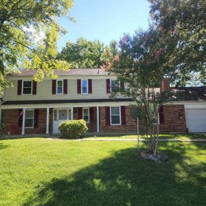 Two-story brick and siding home with front lawn and attached garage exterior view