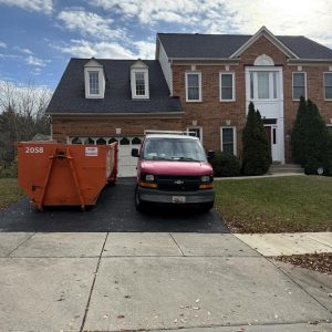 Restoration service van and dumpster parked in front of a residential home.