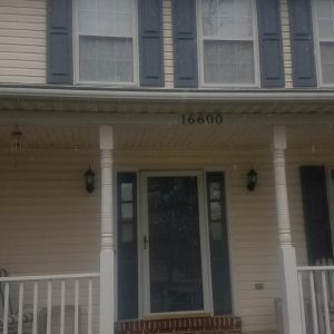 Front porch and entrance of a two-story house with columns and house number 16600.