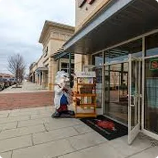 Storefront with a person carrying boxes near the entrance.