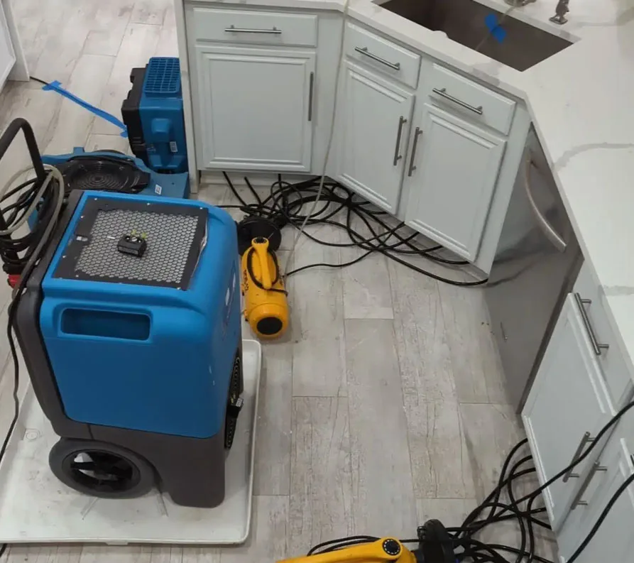 Water damage drying equipment set up in a kitchen.